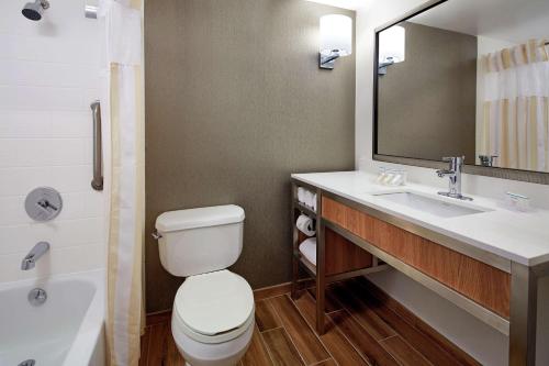 a bathroom with a toilet and a sink and a tub at Hilton Garden Inn Portland Lake Oswego in Lake Oswego