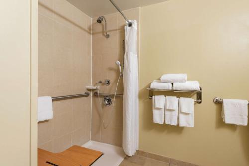uma casa de banho com um chuveiro e toalhas brancas em DoubleTree by Hilton Hotel Grand Rapids Airport em Grand Rapids
