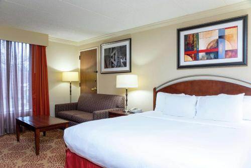 a hotel room with a large bed and a chair at DoubleTree by Hilton Hotel Grand Rapids Airport in Grand Rapids