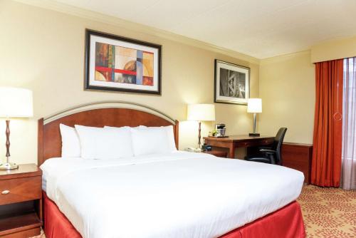 a hotel room with a large bed and a desk at DoubleTree by Hilton Hotel Grand Rapids Airport in Grand Rapids