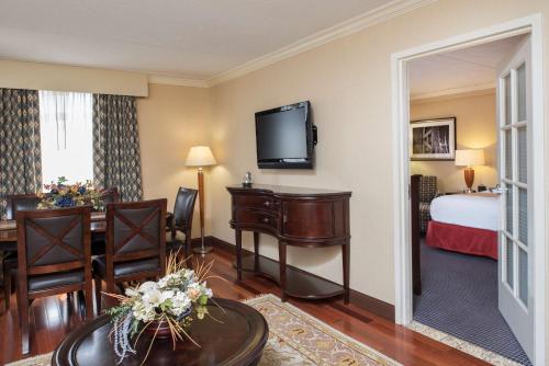 a hotel room with a bedroom and a bed and a table at DoubleTree by Hilton Hotel Grand Rapids Airport in Grand Rapids