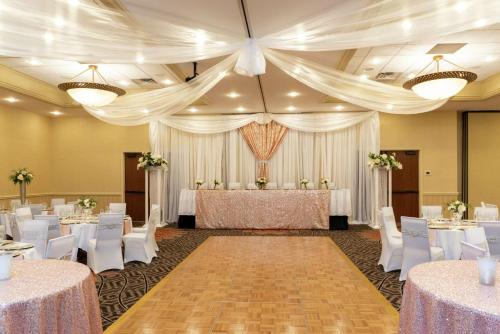 a banquet hall with white tables and white chairs at DoubleTree by Hilton Hotel Grand Rapids Airport in Grand Rapids
