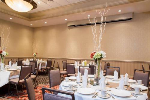 a conference room with tables and chairs and flowers at DoubleTree by Hilton Hotel Grand Rapids Airport in Grand Rapids