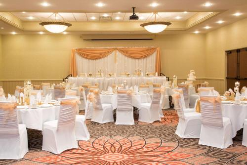 a banquet room with white tables and white chairs at DoubleTree by Hilton Hotel Grand Rapids Airport in Grand Rapids