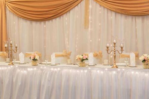 a white table with candles and flowers on it at DoubleTree by Hilton Hotel Grand Rapids Airport in Grand Rapids
