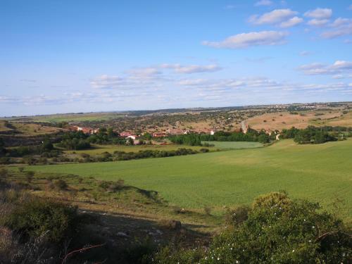 a green field with a town in the distance at Casita Pirón in Adrada de Pirón