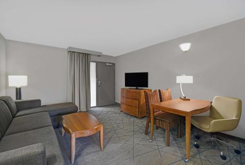 a living room with a couch and a table at Embassy Suites by Hilton Detroit - Livonia/Novi in Livonia