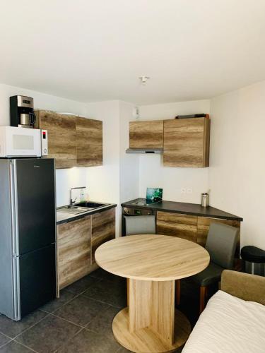 eine kleine Küche mit einem Tisch und einem Kühlschrank in der Unterkunft Large studio with private parking Vallauris in Vallauris