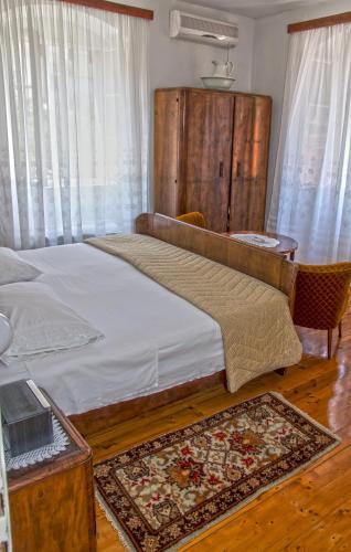 a bedroom with a large bed with a wooden headboard at Marina Rooms in Komiža
