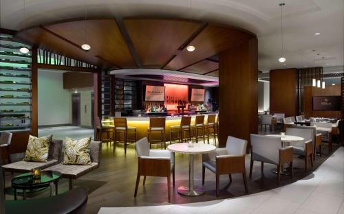 a restaurant with tables and chairs and a bar at Hilton Woodland Hills/ Los Angeles in Woodland Hills