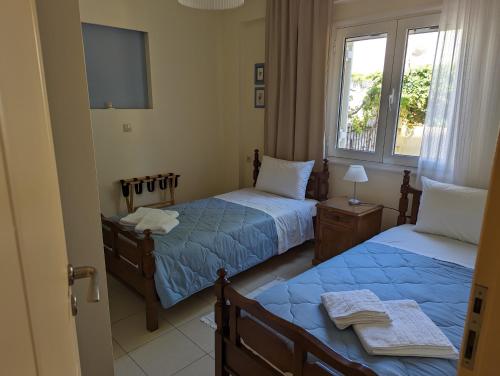 een slaapkamer met 2 bedden, een tv en een raam bij ALMA central apartment in Chania