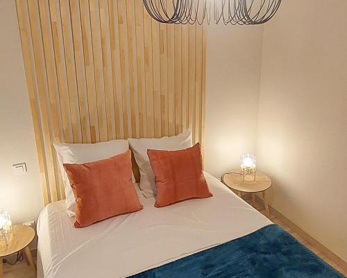 1 Schlafzimmer mit einem Bett mit orangefarbenen Kissen und 2 Tischen in der Unterkunft ArtGrey * Idéal Pro * Roanne Secteur Gare et rue piétonnes in Roanne
