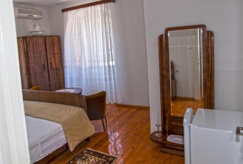 a living room with a bed and a mirror at Marina Rooms in Komiža
