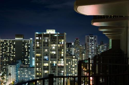 uma vista para o horizonte da cidade à noite em Hilton Waikiki Beach em Honolulu