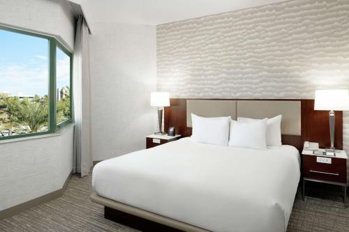 a large white bed in a hotel room with a window at DoubleTree Suites by Hilton Phoenix in Phoenix
