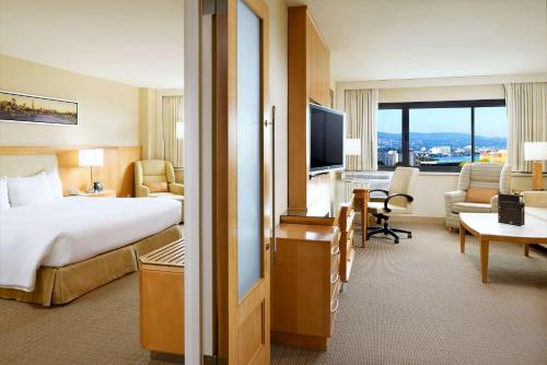 a hotel room with a bed and a living room at Hilton San Francisco Airport Bayfront - No Resort Fee in Burlingame