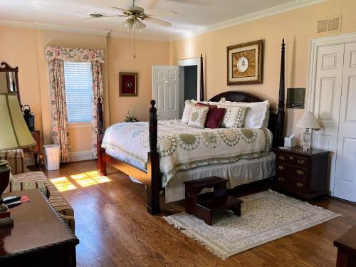 a bedroom with a bed and a table and a couch at The Virginia Cliffe Inn in Glen Allen