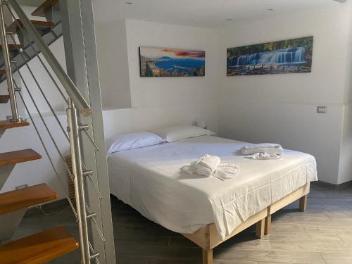1 dormitorio con 1 cama con toallas en Suites Caracciolo, en Nápoles