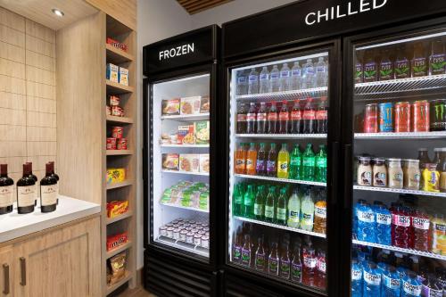 a refrigerator filled with lots of different types of drinks at Hilton Garden Inn Long Island City in Queens