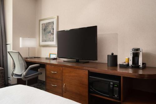 a hotel room with a desk with a television on it at Hilton Garden Inn Long Island City in Queens