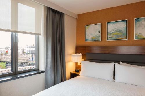 a hotel room with a bed and a window at Hilton Garden Inn Long Island City in Queens