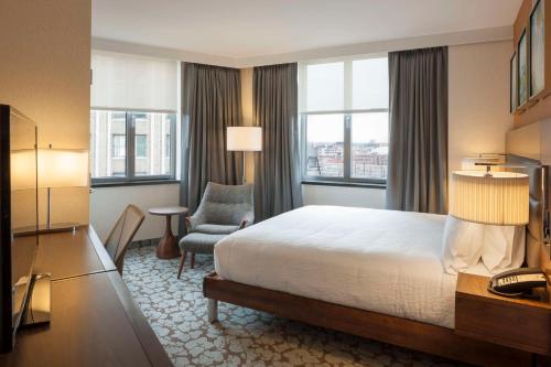 a hotel room with a bed and a chair at Hilton Garden Inn Long Island City in Queens