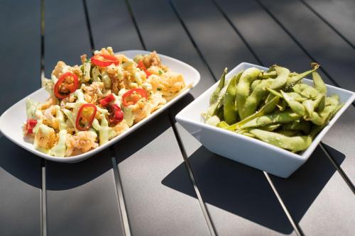 two plates of food and a bowl of vegetables at DoubleTree by Hilton San Francisco Airport North Bayfront in Brisbane