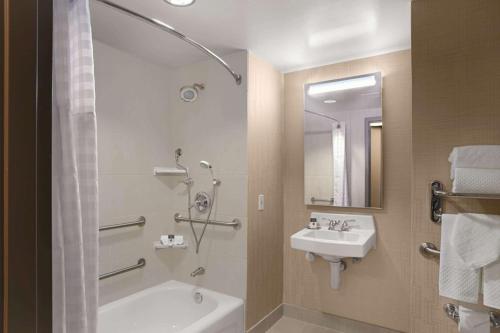 a bathroom with a tub and a sink and a shower at DoubleTree by Hilton San Francisco Airport North Bayfront in Brisbane