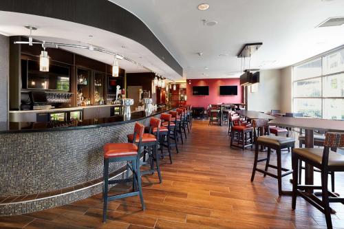 a restaurant with a bar with chairs and tables at DoubleTree by Hilton San Francisco Airport North Bayfront in Brisbane