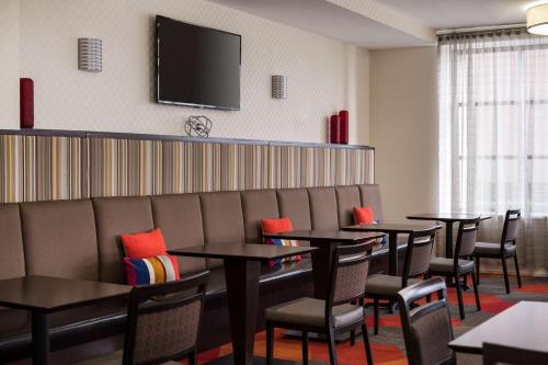 a dining room with tables and chairs and a tv at Homewood Suites by Hilton-Anaheim in Anaheim