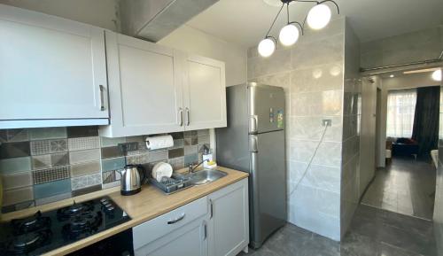 a kitchen with white cabinets and a stainless steel refrigerator at Newly Refurbished 2 Bedroom Apartment in the Heart of Istanbul in Istanbul