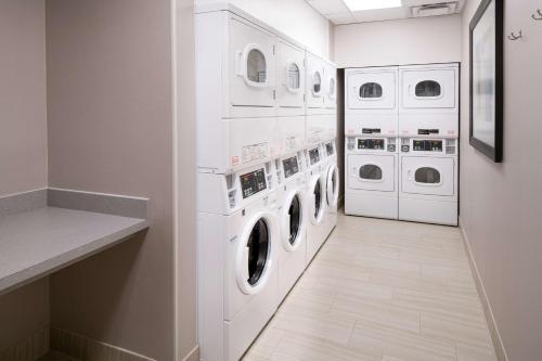 a laundry room with white washers and dryers at Homewood Suites by Hilton Aliso Viejo Laguna Beach in Aliso Viejo