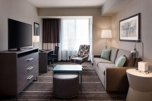 a living room with a couch and a tv at Homewood Suites by Hilton Aliso Viejo Laguna Beach in Aliso Viejo