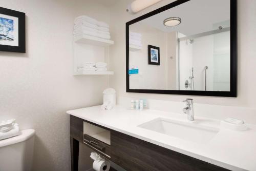 a bathroom with a sink and a mirror at Hampton Inn & Suites Anaheim Garden Grove in Anaheim