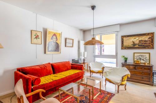 un salon avec un canapé rouge et une table dans l'établissement Appartement Molière - Welkeys, à Avignon