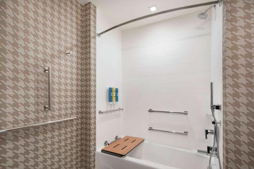 丹佛Home2 Suites By Hilton Denver Downtown Convention Center的带白色浴缸和水槽的浴室
