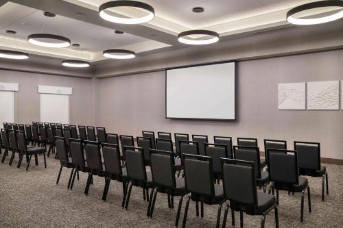 a conference room with chairs and a screen at Home2 Suites By Hilton Denver Downtown Convention Center in Denver
