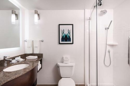 a bathroom with a shower and a toilet and a sink at Hilton Garden Inn Denver/Cherry Creek in Denver