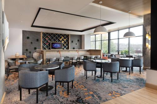 a restaurant with tables and chairs and windows at Hampton Inn & Suites Watertown Boston, Ma in Watertown