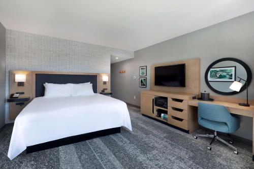 a hotel room with a large bed and a television at Hampton Inn & Suites Watertown Boston, Ma in Watertown