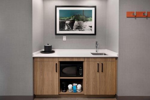 uma cozinha com um lavatório e um balcão com um micro-ondas em Hampton Inn & Suites Watertown Boston, Ma em Watertown