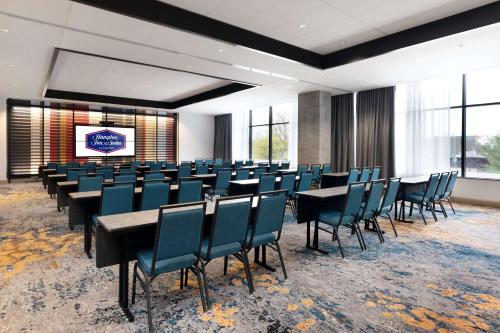 a conference room with tables and chairs and a screen at Hampton Inn & Suites Watertown Boston, Ma in Watertown