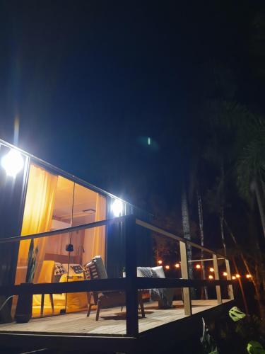 een balkon van een huis met een tafel en stoelen in de nacht bij Vale Dos Pinheiros in Rio Forcação