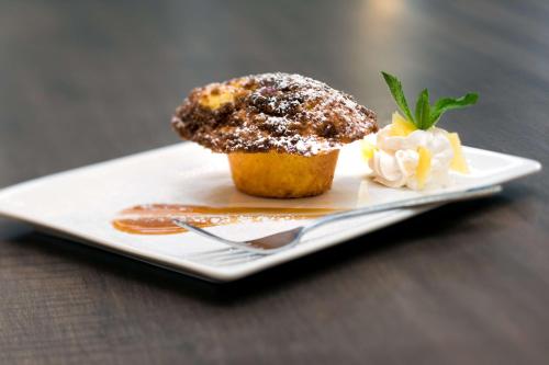 a chocolate muffin on a plate with a fork at Embassy Suites by Hilton Austin Central in Austin