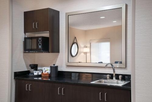 eine Küche mit einem Waschbecken und einem Spiegel in der Unterkunft Hampton Inn Boulder/Louisville in Louisville