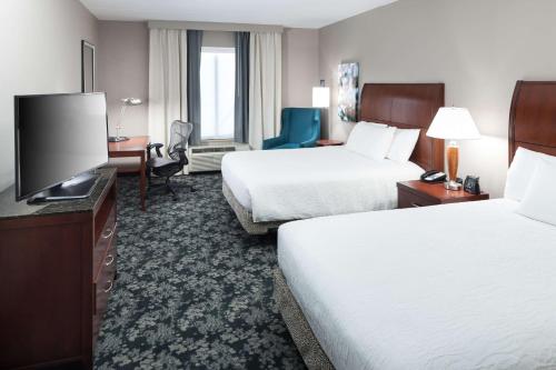 um quarto de hotel com duas camas e uma televisão de ecrã plano em Hilton Garden Inn Frisco em Frisco