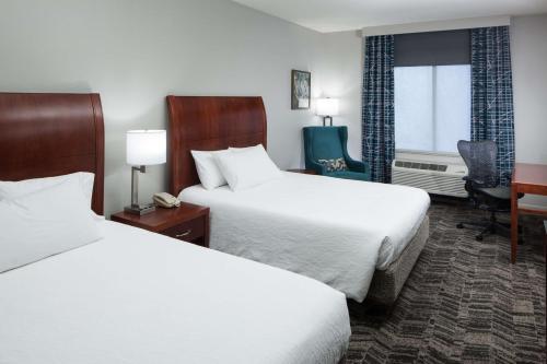 a hotel room with two beds and a desk at Hilton Garden Inn Tucson Airport in Tucson