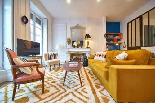 - un salon avec un canapé jaune et une cheminée dans l'établissement Charmant cocon lyonnais Sathonay-Terreaux, à Lyon