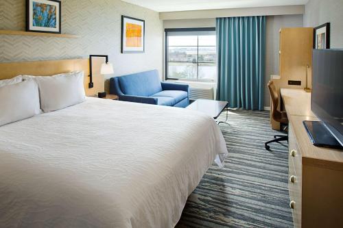 a hotel room with a bed and a chair and a television at Hilton Garden Inn Providence in Providence