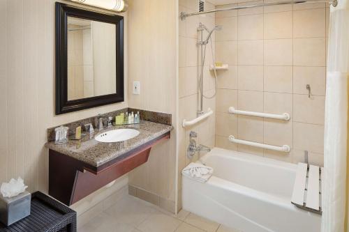 a bathroom with a tub and a sink and a bath tub at DoubleTree by Hilton Los Angeles/Commerce in Commerce